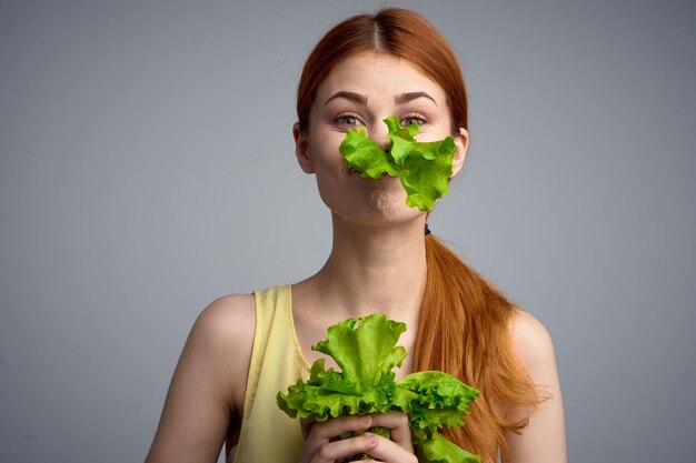 Foto sezione centrale di una donna che tiene un fiore contro la parete