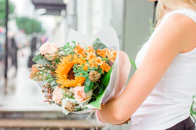 Foto sezione centrale di una donna che tiene dei fiori