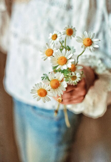 Photo midsection of woman holding flowers