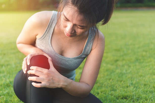 Midsection of woman holding hands on field