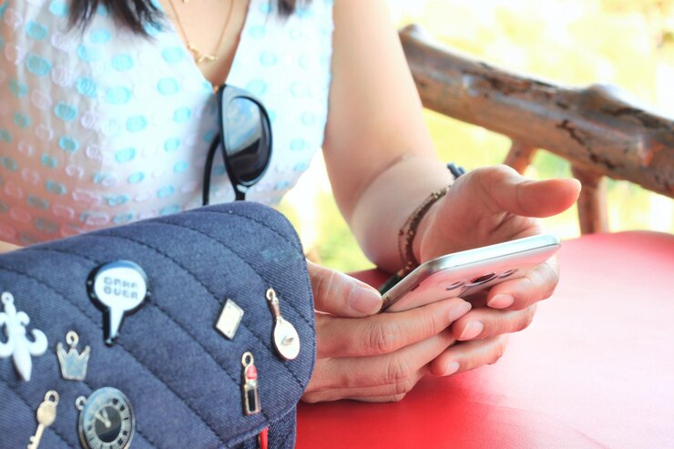 Midsection of woman holding hands while sitting outdoors