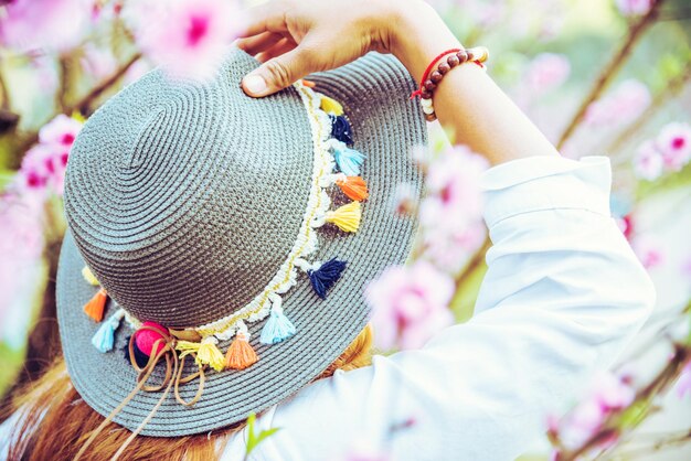 Foto sezione centrale di una donna che tiene il cappello