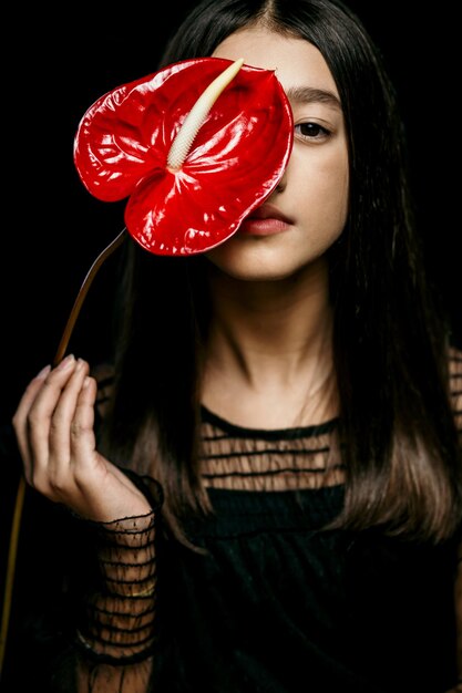 Photo midsection of woman holding heart shape against black background