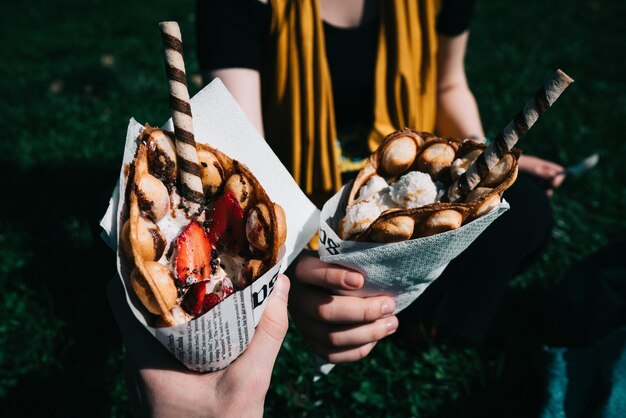 Foto sezione centrale di una donna che tiene un piatto di specialità di gelato in una tazza