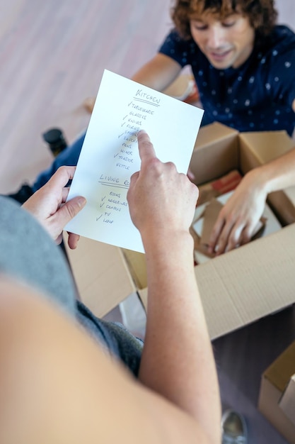 Midsection of woman holding list over man at home