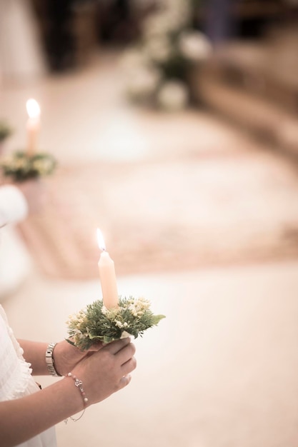 Midsection of woman holding lit candle