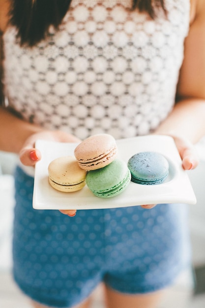 Photo midsection of woman holding macaroons