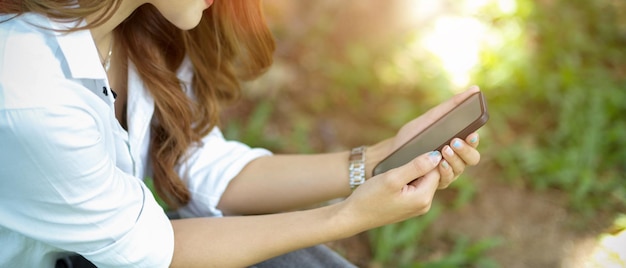 Photo midsection of woman holding mobile phone outdoors