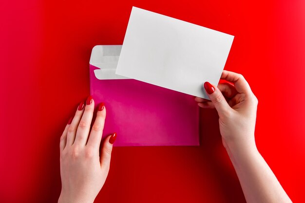 Midsection of woman holding paper against red background