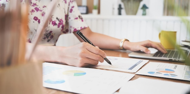 Midsection of woman holding paper with text on table