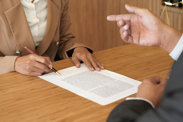 Midsection of woman holding paper with text on table