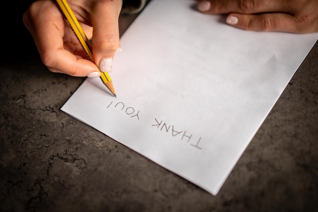 midsection of woman holding paper with text