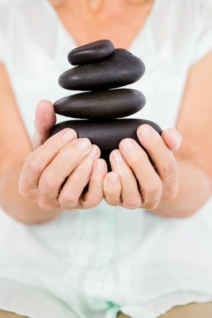 Midsection of woman holding pebbles