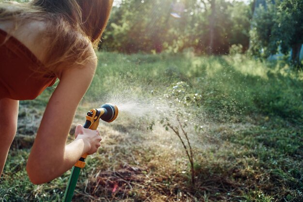 Foto sezione centrale di una donna che tiene una pianta sul campo