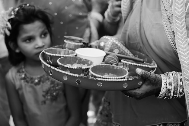 Photo midsection of woman holding plate with bowls during ceremony