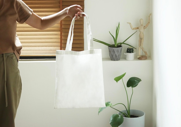 Photo midsection of woman holding potted plant at home