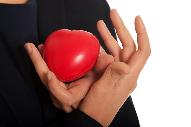 Midsection of woman holding red stress ball over white background