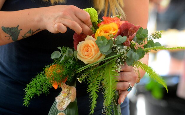 Foto sezione centrale di una donna che tiene un bouquet di rose
