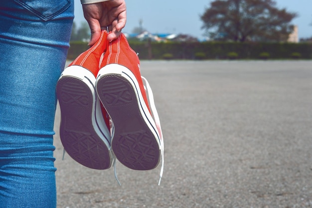 Foto sezione centrale di una donna che tiene le scarpe