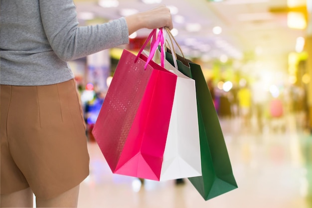 ショッピングバッグを持った女性がモールに立っている中間部分