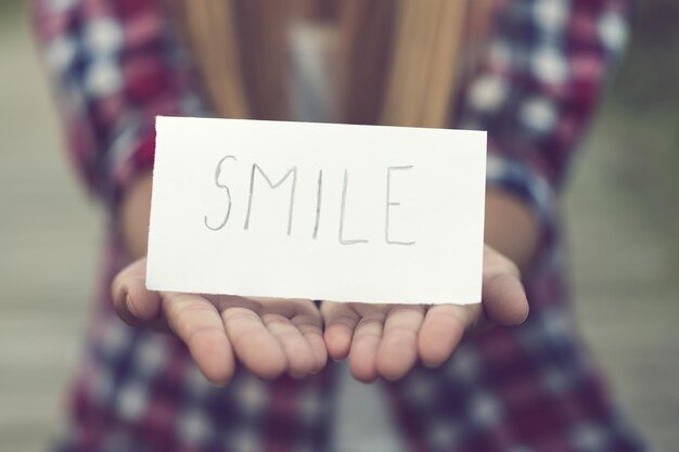 Foto sezione centrale di una donna che tiene un testo sorridente su carta