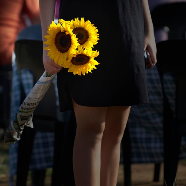 Foto sezione centrale di una donna che tiene il girasole