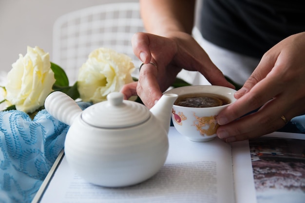 Photo midsection of woman holding tea cup on table