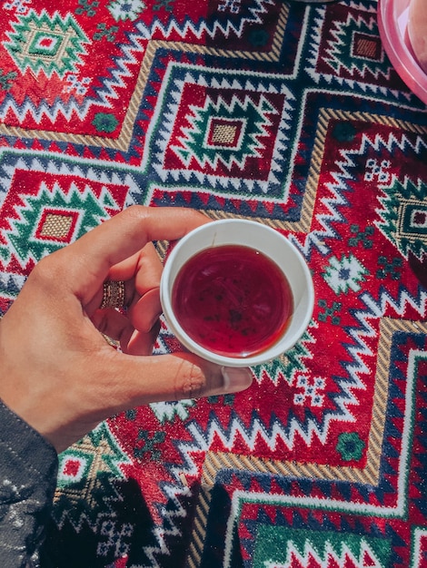 Foto sezione centrale di una donna che tiene in mano una tazza di tè