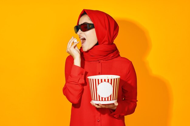 Midsection of woman holding umbrella against yellow background