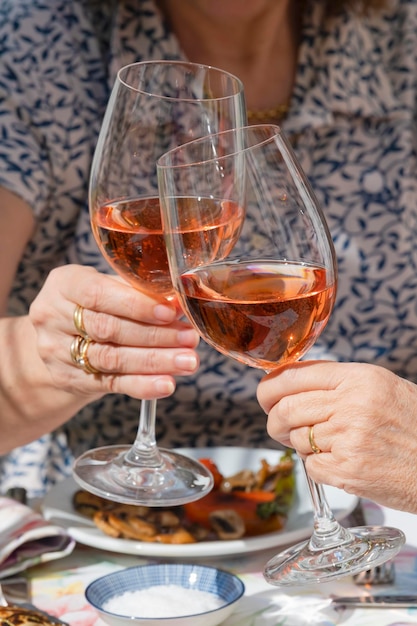 Foto sezione centrale di una donna che tiene un bicchiere di vino sul tavolo