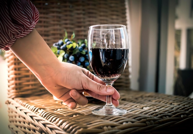 Photo midsection of woman holding wineglass on table