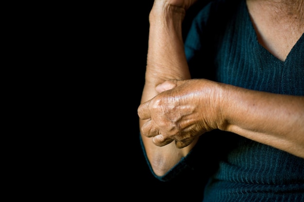 Foto sezione centrale della mano di una donna che prude su uno sfondo nero
