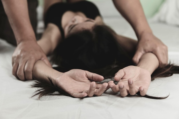 midsection of woman lying on bed