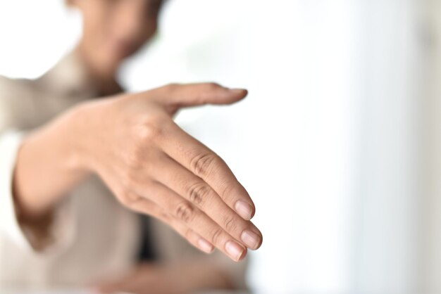 Midsection of woman offering handshake in office