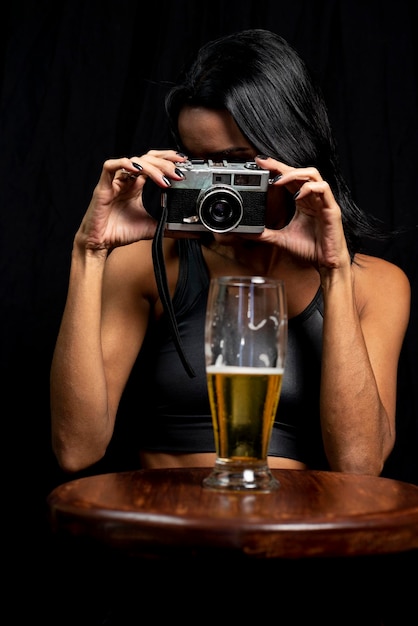 Foto sezione centrale di una donna che fotografa con un bicchiere di birra