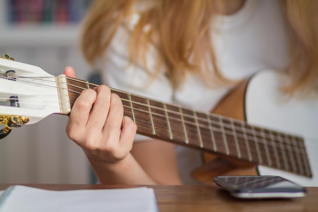 Midsection of woman playing guitar