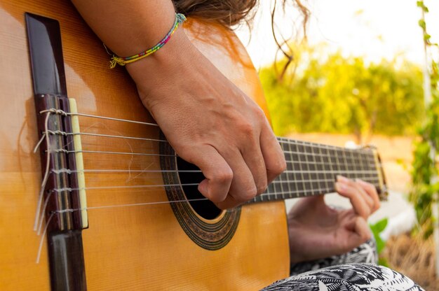 Midsection of woman playing guitar