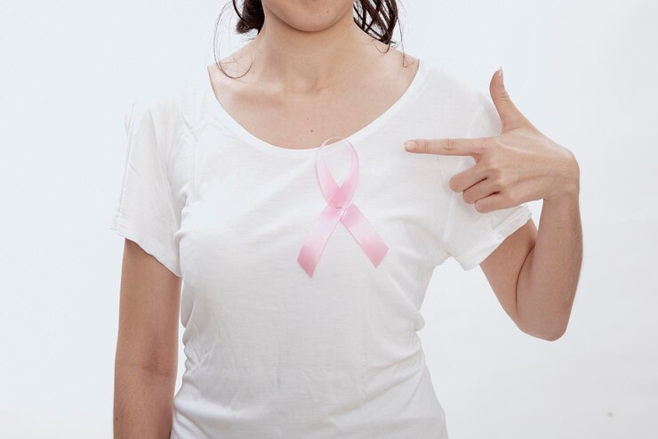 Photo 白い背景の乳がん意識リボンを指さしている女性の真ん中