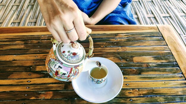 Photo midsection of woman pouring tea