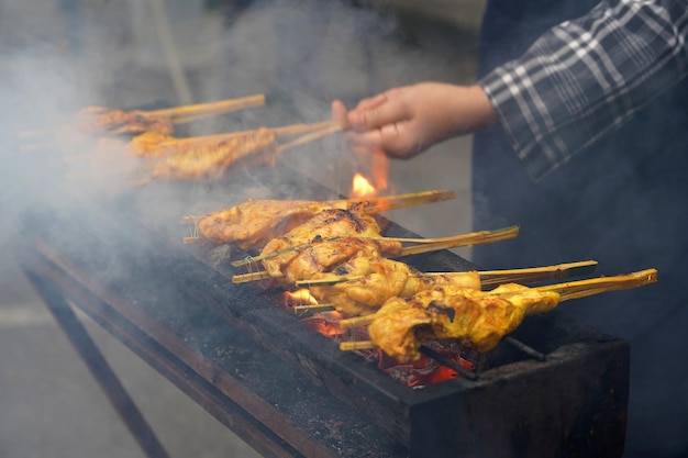 midsection of woman preparing food on barbecue grill