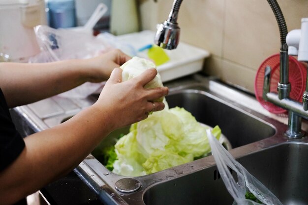 Photo midsection of woman preparing food in kitchen at home