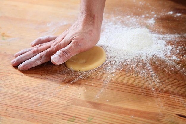 Foto sezione centrale di una donna che prepara cibo da forno dolce con pasta al bancone della cucina