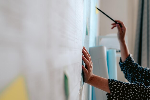 Photo midsection of woman reading book against wall