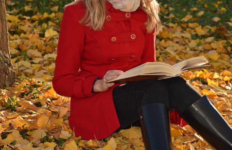 Photo midsection of woman reading book on field during autumn