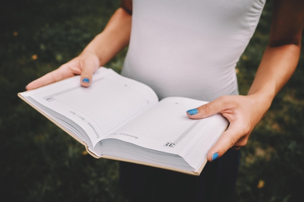 Foto sezione centrale di una donna che legge un libro su carta