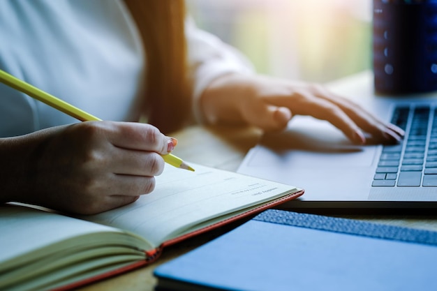 Midsection of woman reading book on table