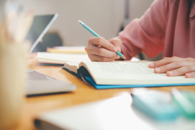 Midsection of woman reading book on table