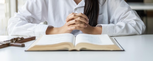 Midsection of woman reading book on table