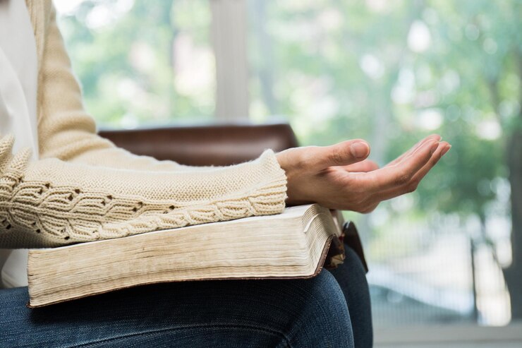 Photo テーブルで本を読んでいる女性のミッドセクション