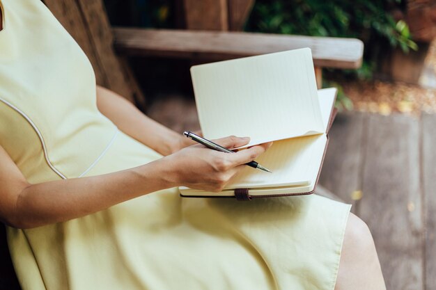 Photo midsection of woman reading book while sitting on table